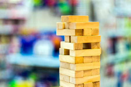 close up wood block in jenga game on blur background 