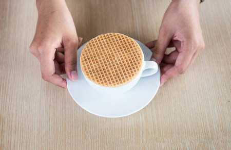 close up stroopwaffle on hot coffee cup serve on wood table and copy spaceの写真素材