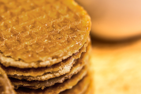 marco shot piece of brown homemade stroopwafel snack and on wood table and copy space for text made from daugh and syrup in original tast from dutchの写真素材