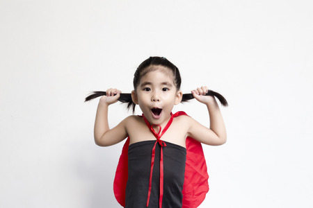 funny action of asian girl with black dress and red shawl in halloween or hero concept on white backgroundの写真素材