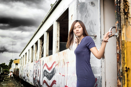 asian thai lady model post action tourism hold old train in dark clound conceptの写真素材