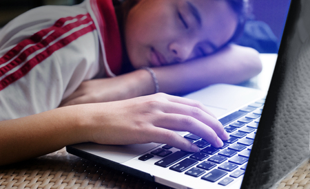 select focus hand of sleeping asian girl with computer is behavior of digital generationの写真素材