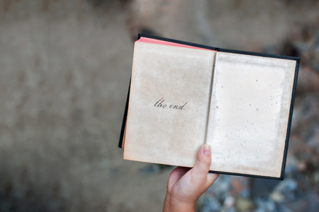 kid hand open last page of old book story on blur backgroundの写真素材