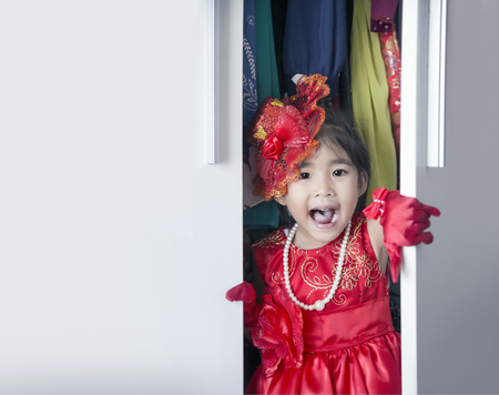 An Asian girl love to play dress up in wardrobe and copy space on white for textの写真素材