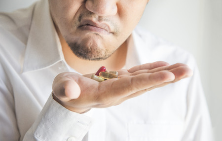 shabby asian man need to eat vitamin or drug for health when workaholic lifestyleの写真素材