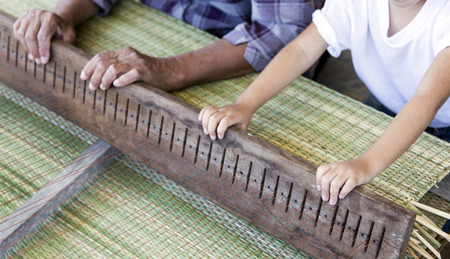 focus kid hand with old hand make handmade rattan from dry leaf and rope inherit conceptの写真素材