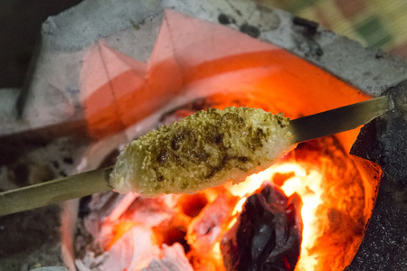 close up sticky rice and egg with bamboo stick grilled on hot coalの写真素材