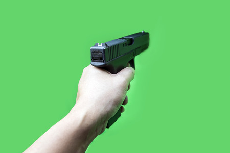 cloes up hand hold gun on green screen の写真素材