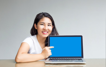 asian woman point to blank laptop screen to display content inside の写真素材