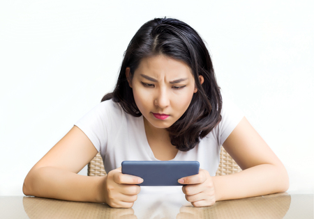 asian woman play game in mobile serious feeling on tableの写真素材