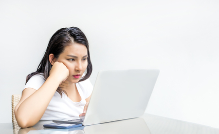 asian woman serious action use laptop to find somethingの写真素材