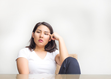 thinking asian woman siting on chair and table look out of spaceの写真素材