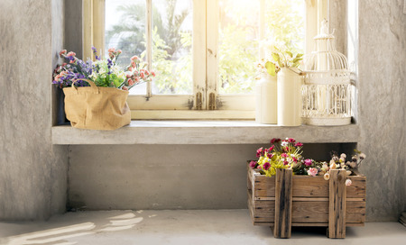 decoration in door balcony with artificial flower with steel vase and cage and wood box  cement building in vintage style with still lightの写真素材