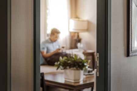 focus wood frame door to living room with blur shot man relax in living room の写真素材