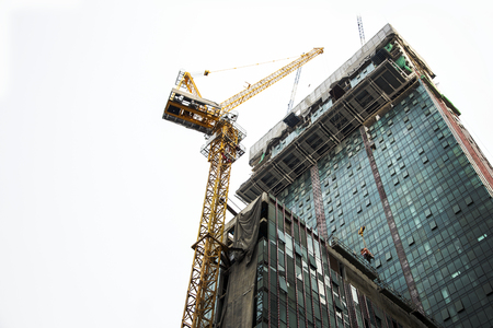 Crane and building construction site against blue sky.Under construction conceptの写真素材