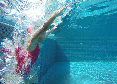 moving action of asian kid swimming underwater in summer. Outdoor activities in swimming pool. Zoom motion in poolの写真素材