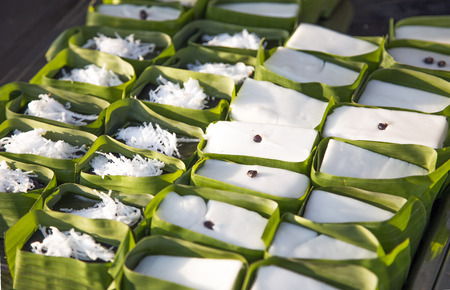 close up thai coconut custard dessert with banana leaf in bakery shop.の写真素材