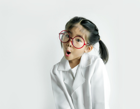 asian girl with big glass and science suite action on white screen. Funny  Action kid model with doctor or science costume.の写真素材