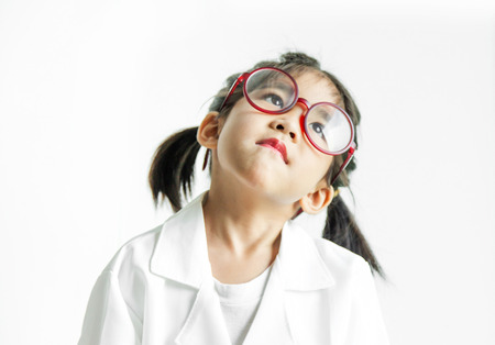 asian girl with big glass and science suite action on white screen. looking up Action kid model with doctor or science costume.の写真素材