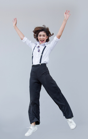 funny face from asian lady jumping on blank background. Happy people action with healthy face with good.の写真素材