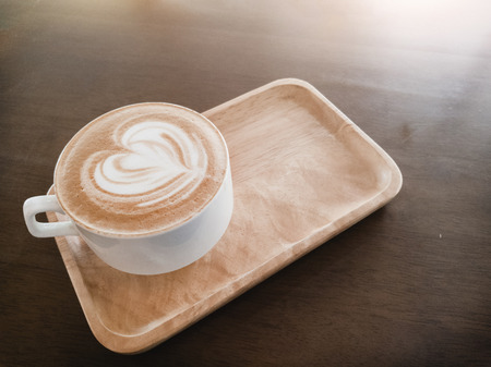 latte heart coffee in corner of wood plate at cafe. coffee and tea in morning from top viewの写真素材