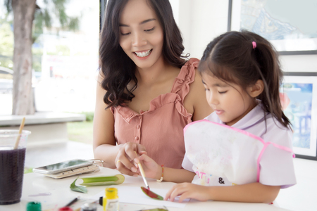 asian mother and daughter painting water color to make art object in creative activities.の写真素材