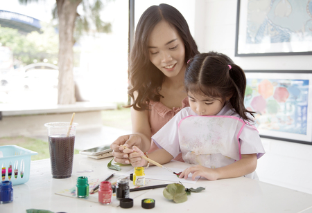asian mother and daughter painting water color to make art object in creative activities.の写真素材