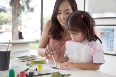asian mother and daughter painting water color to make art object in creative activities.の写真素材
