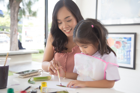 focus happy face of asian mother do painting with kids.の写真素材