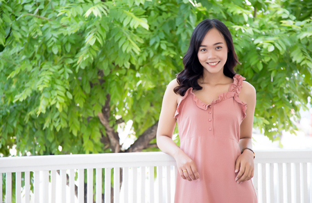 beauty asian girl smile action on balcony at home with tree for backgroundの写真素材