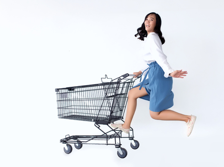 happy asian girl loveshopping  with shopping cart ,teenage shopaholic conceptの写真素材