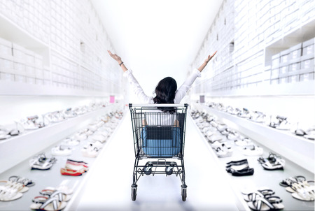 happy asian girl in shopping cart enjoy to shoping fashion shoes shopの写真素材