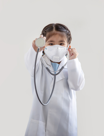 asian kids with air polution protect mask and stethoscope with  doctor suite costume. Portrait action as block smoke smell on blue background (include clipping path)の写真素材