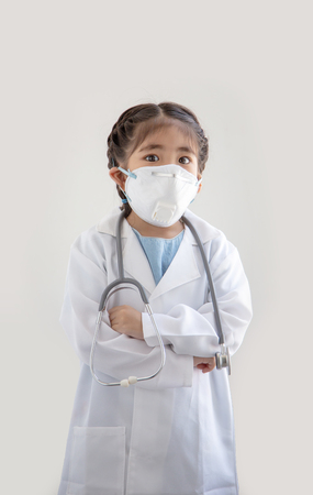asian kids with air polution protect mask and stethoscope with  doctor suite costume. Portrait action as block smoke smell on blue background (include clipping path)の写真素材