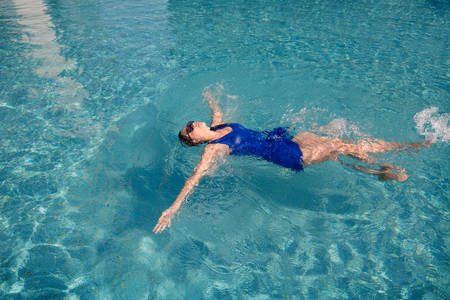 asian girl with swimming suite and sun glasses relax on swimming pool.Relax lifestyle with water concept.の写真素材