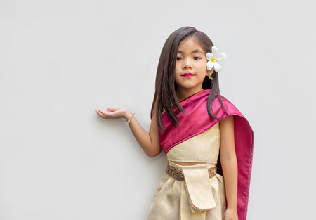 asian Thai kids with Thai tradition dress. Asian girl open hand action for present or suggestion with hand.の写真素材