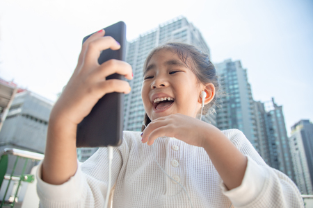 young kid use smart phone to communication with online communication in digital litaracy concept in urban city lifestyle.の写真素材