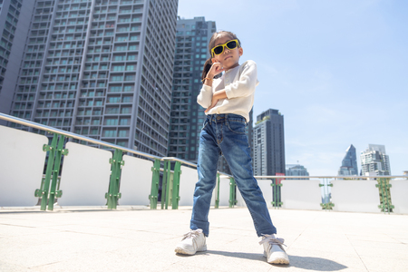 portrait confidence asian kid portrait posting on sky train in capital urban lifestyle with casual suite in new generation lifestyle concept.の写真素材