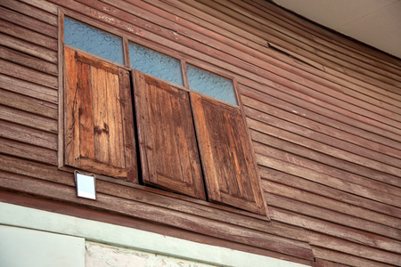 wood window exterior old Thai home style (mirror hanking on window for reflex bird to get in)の写真素材