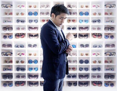 confident metro man dress up on sunglasses collection on shelf for fashion wear. Fashion design conceptの写真素材