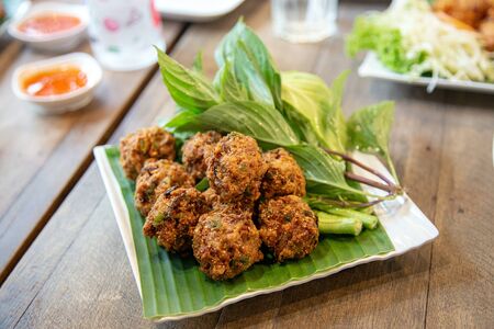 asian crispy Thai cusine call "Larb Thod" inside with herb and pork grill in ball. serve with vegetableの写真素材