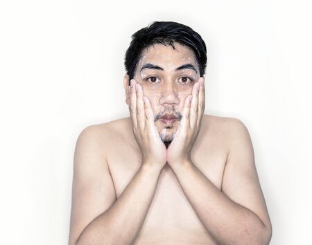 close up face of asian man cleansing face with soft foam and look at camera on white background in skin care cosmetic conceptの写真素材