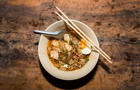 thai spicy noodle with pork and boild egg serve on wood tableの写真素材