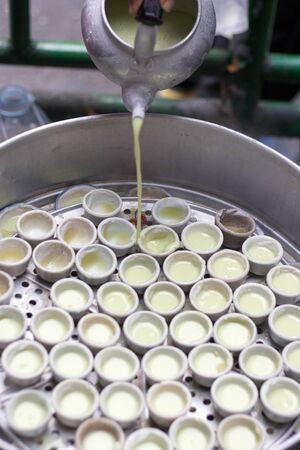 cooking boild sweet cake coconut dessert with ceramic cup on hot steamingの写真素材