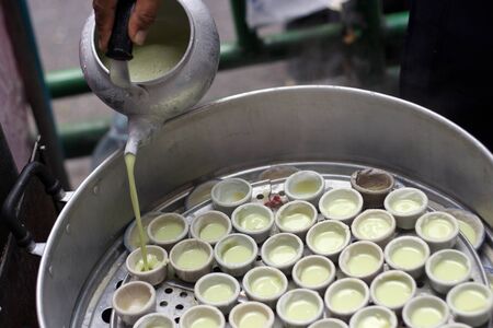 cooking boild sweet cake coconut dessert with ceramic cup on hot steamingの写真素材