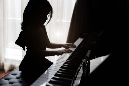 Silhouette kids playing pianoの写真素材