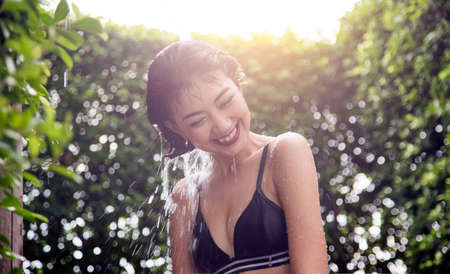 asian woman happy to shower outdoor activities after swim for good healthyの写真素材