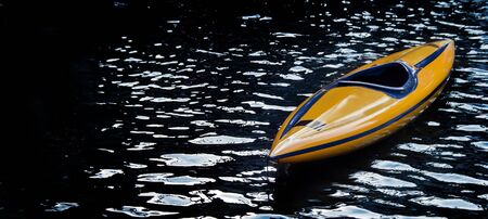 Empty kayak boat on dark water with banner size