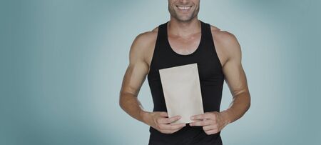 Close up shot muscle man holding blank paperの写真素材