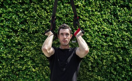 fit exercise outdoor with rubber band to body building and muscle for healthy from smart man (include path)の写真素材